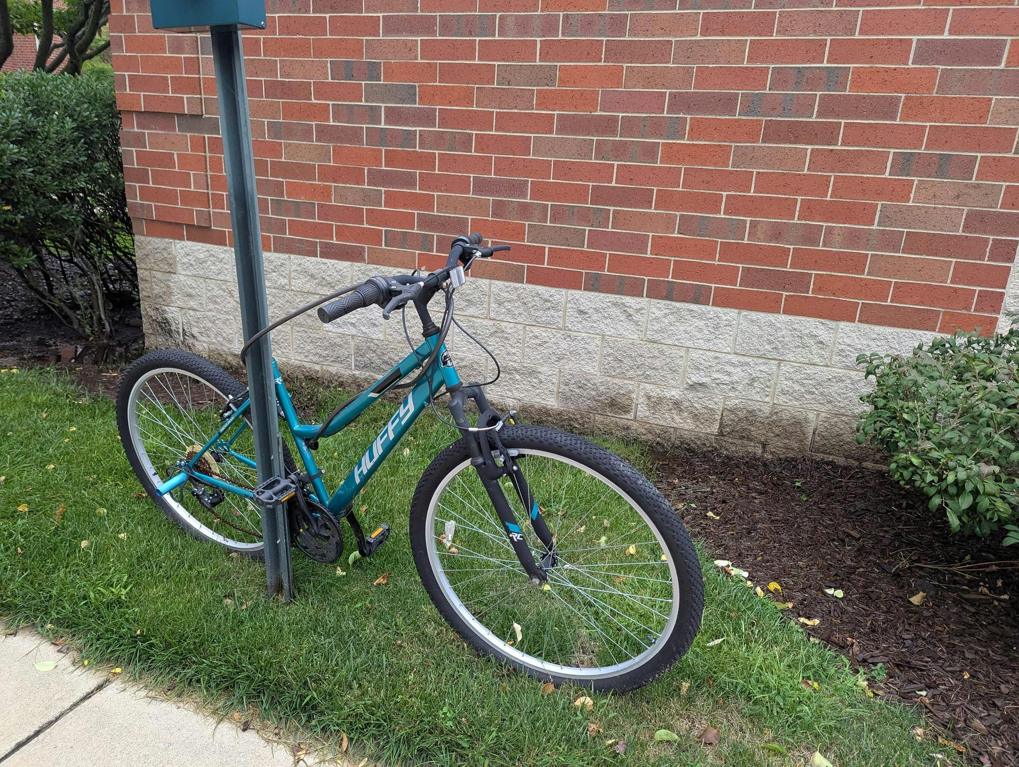 A bike sits chained to a pole.