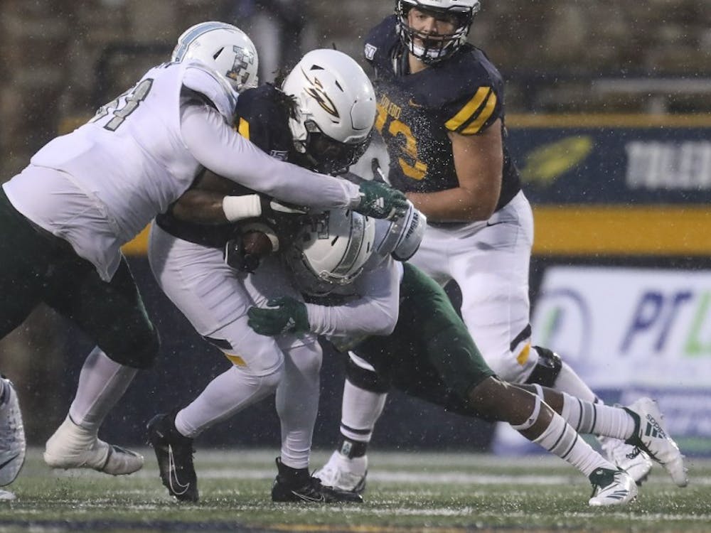 Toledo&#x27;s Desmond Phillips (10) is brought down by Eastern Michigan&#x27;s Aaron Hamilton (51) and Jerodd Vines (15) during a MAC football game at the University of Toledo&#x27;s Glass Bowl in Toledo, Ohio on Saturday October 26, 2019. THE BLADE/REBECCA BENSON