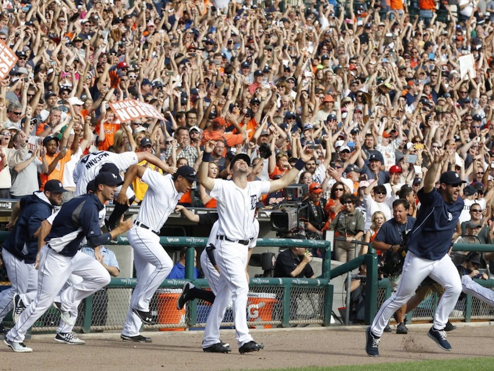 Detroit Tigers players run out of the dugout to joint the on-field celebration after their win over the Minnesota Twins clinched the American League Central Division on Sunday, Sept. 28, 2014, at Comerica Park in Detroit. (Julian H. Gonzalez/Detroit Free Press/MCT)