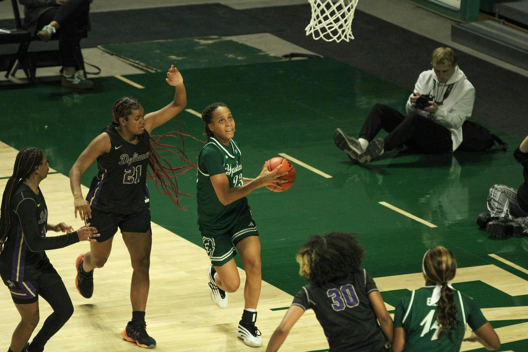 #23 Peyton Hill, in a green Eastern Michigan University jersey, laying up the basketball