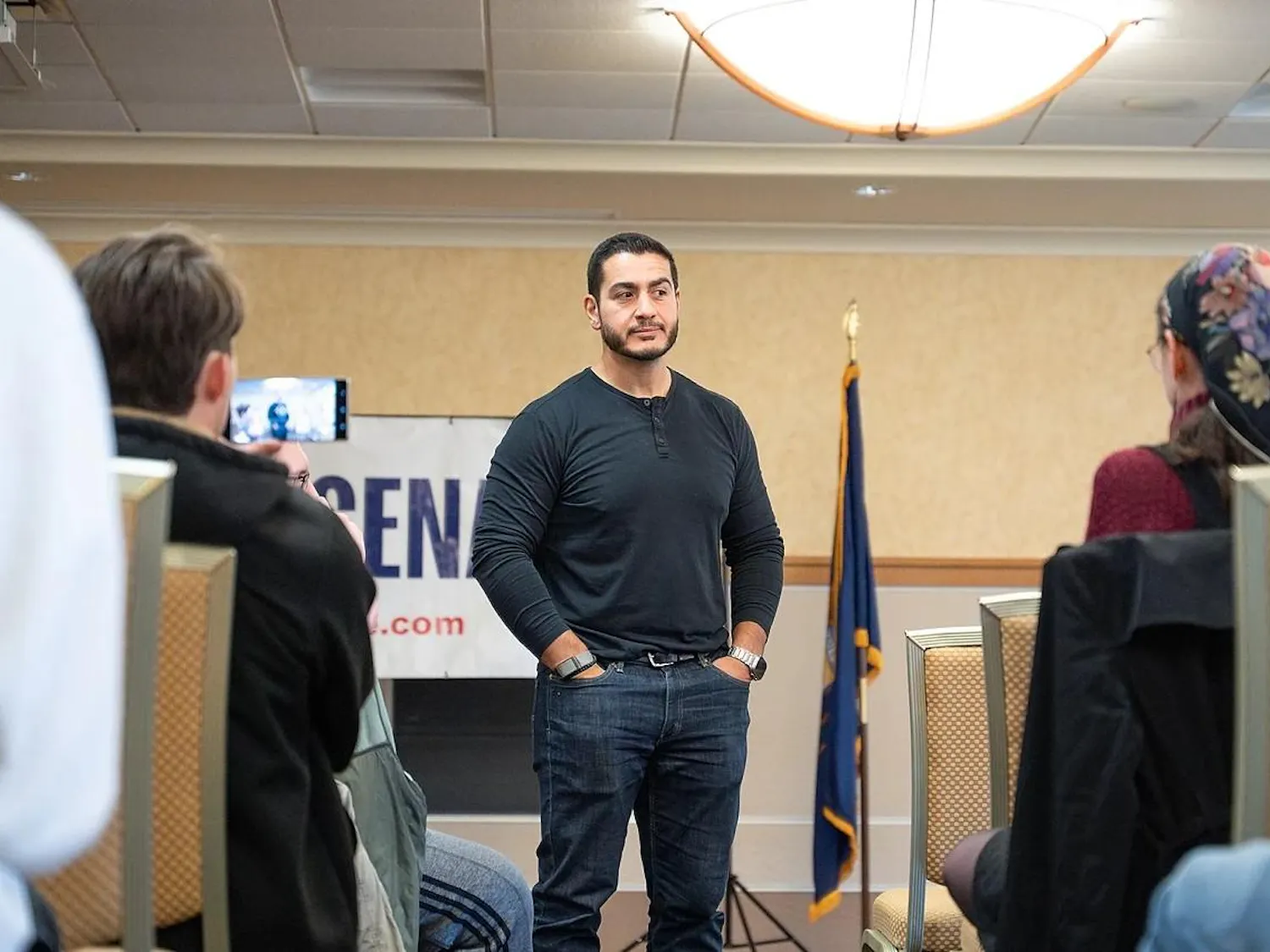 Abdul El-Sayed speaks with attendees, who sit in rows of chairs.