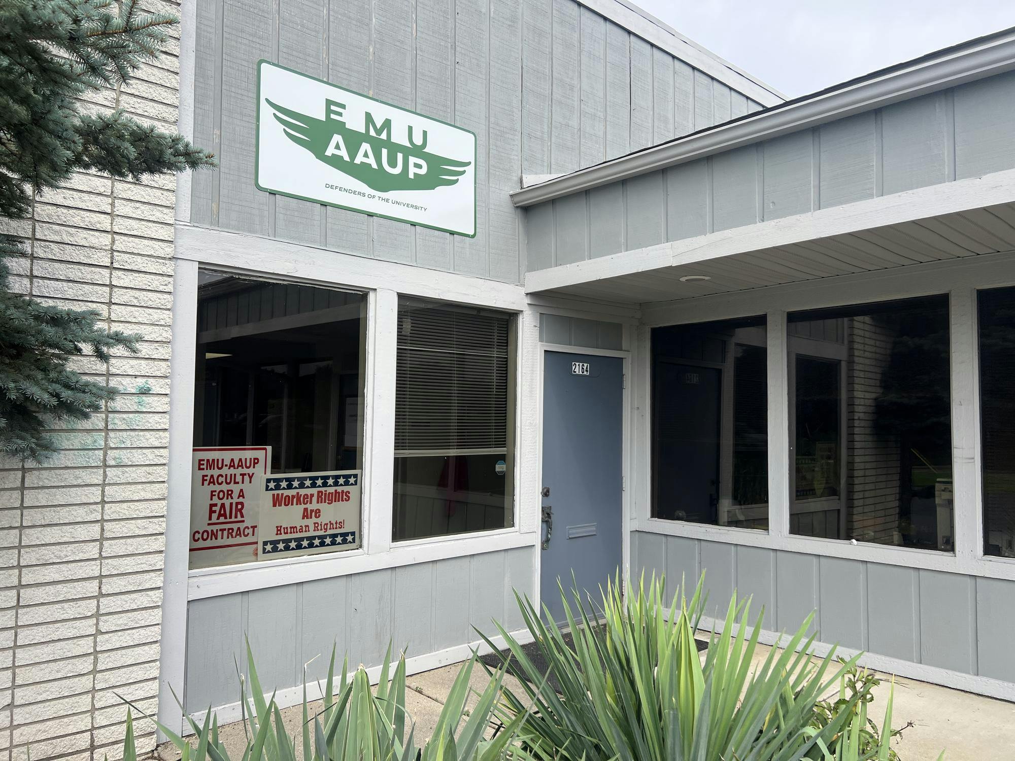 The exterior of the EMU-AAUP office. Two signs can be seen in the window reading "EMU-AAUP faculty for a fair contract" and "Worker rights are human rights!"