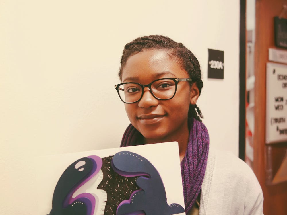 Artist Sharelle Krisel, holding a piece of artwork she created