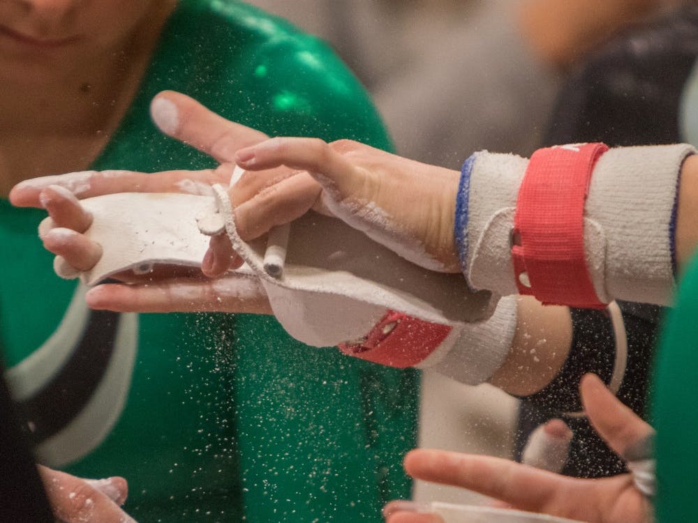 Eastern Michigan gymnasts chalk up before their bars rountines in the Eagles 3rd place finish in their Quad Meet in East Lansing on March 6 2015.