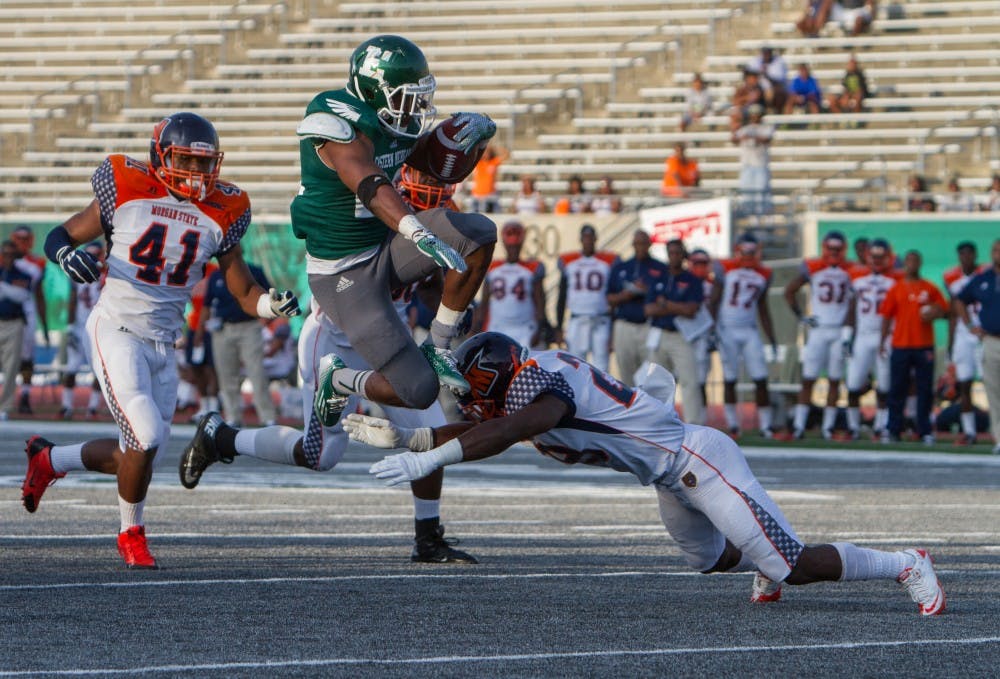 Eastern Michigan running back Ryan Brumfield (22) leaps over a Morgan State player for a touchdown in the Eagles 31-28 victory over Morgan State Saturday night in Ypsilanti.