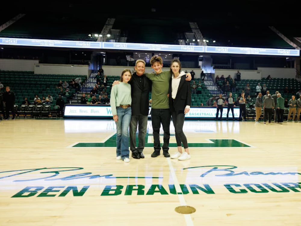 Ben Braun's family, including his wife, Jessica, their son Julius, and their daughter Eliza, joins him on the court Saturday, Nov. 18, 2023, as Eastern Michigan University celebrates the naming of the court in honor of the legendary coach. Braun holds more wins during his 11 years at Eastern than any other EMU basketball coach.