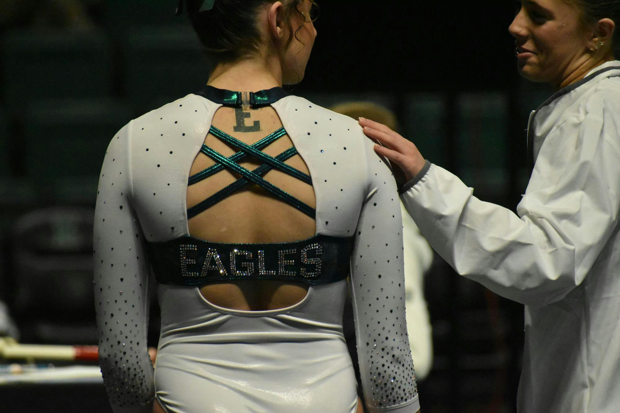 Gymnast Analiah Solorio faces away from the camera as she speaks with teammate Kyrie Lowe.