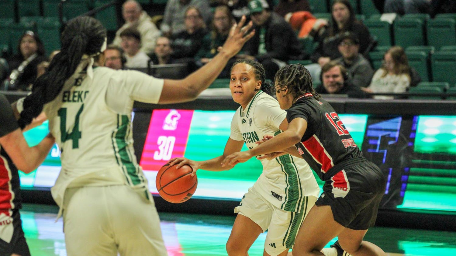 EMU player, in a white jersey, looking to pass the ball.