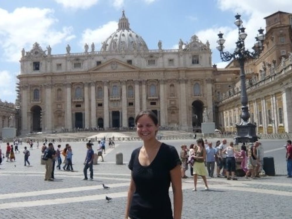 Senior Abbey Ventrone stands in St. Peter’s Square in the Vatican with St. Peter’s Basilica in the background during an EMU Study Abroad program.