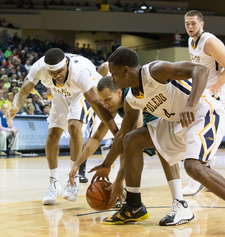 Eastern Michigan guard J.R. Sims dives between two Toledo players for the ball in the Eagles 77-66 loss to Toledo Saturday afternoon.