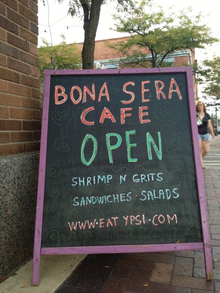 	On the corner of West Michigan Avenue and Washington Street stands Bona Sera Café, with its twinkling lights in the windows and brightly colored chalkboard listing today’s specials outside.