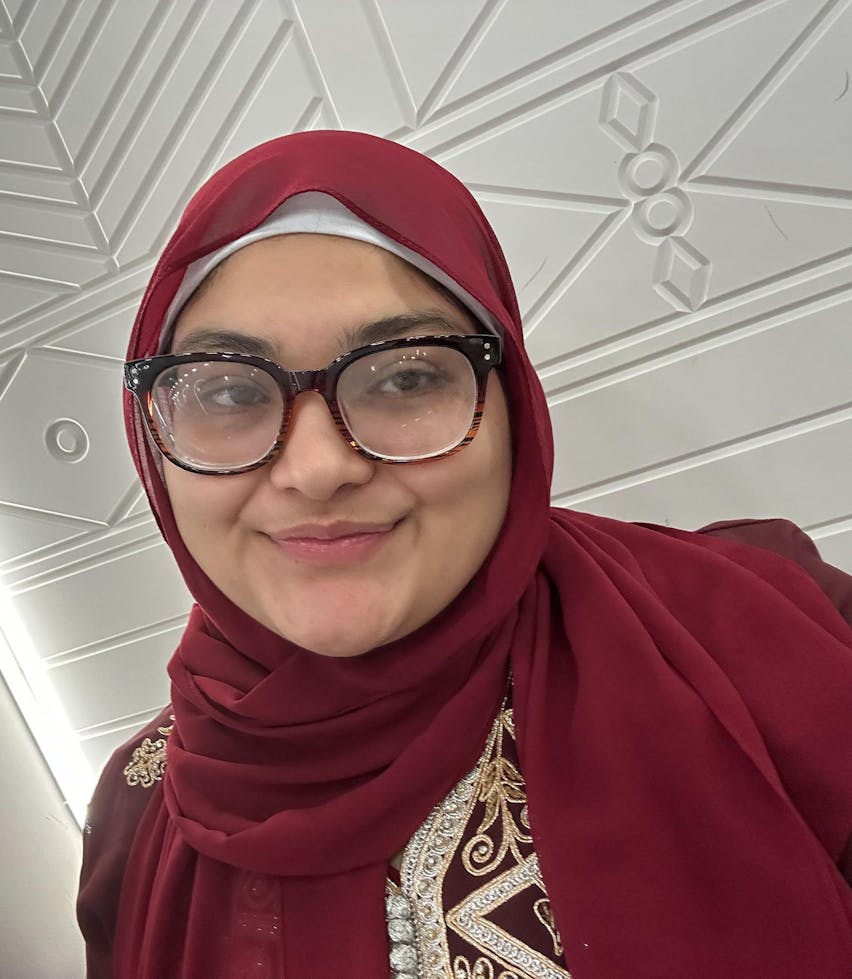 Headshot of Zeinab Agbaria, from the shoulders up, smiling.