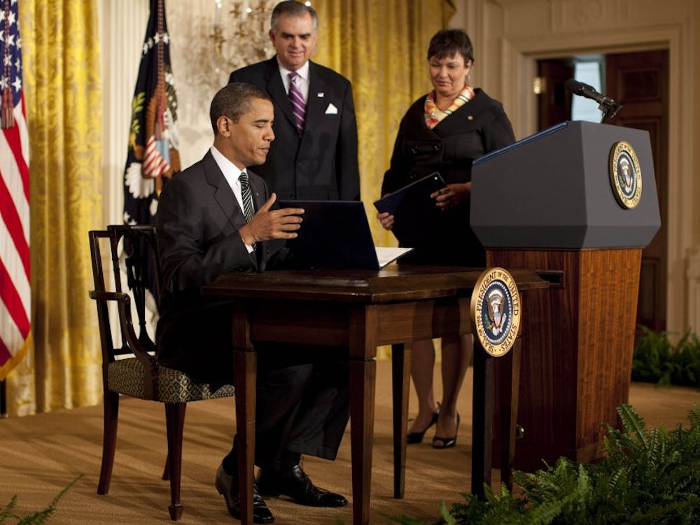 President Barack Obama signs an executive order dealing with climate change. To his right are EPA Administrator Lisa Jackson and Transportation Secretary Ray LaHood.