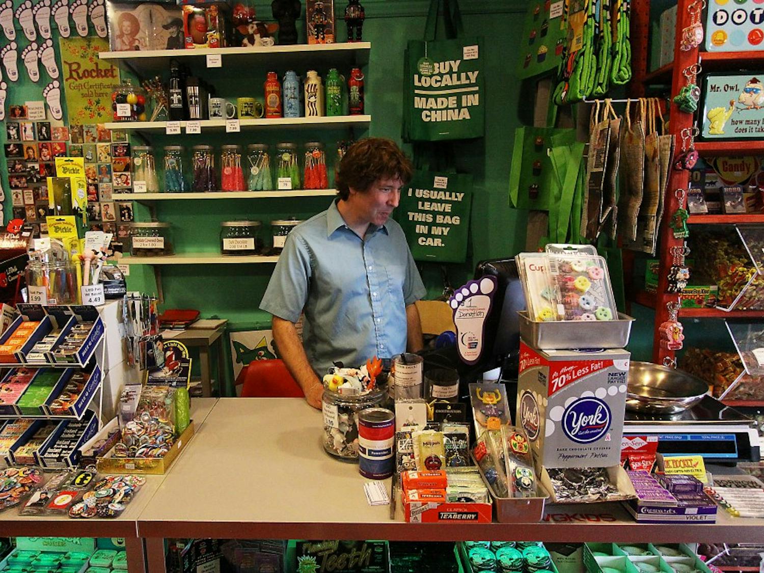 Paul Balcom, co-owner of The Rocket, stands behind the counter in his store on W. Michigan Avenue, which sells T-shirts, coffee mugs and post cards, many of which are focused on Ypsilanti.