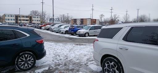 An image of snow covered cars in a parking lot. 