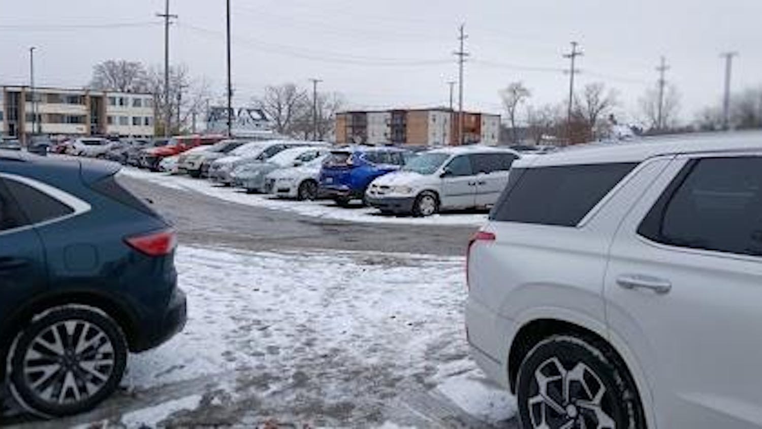 An image of snow covered cars in a parking lot.