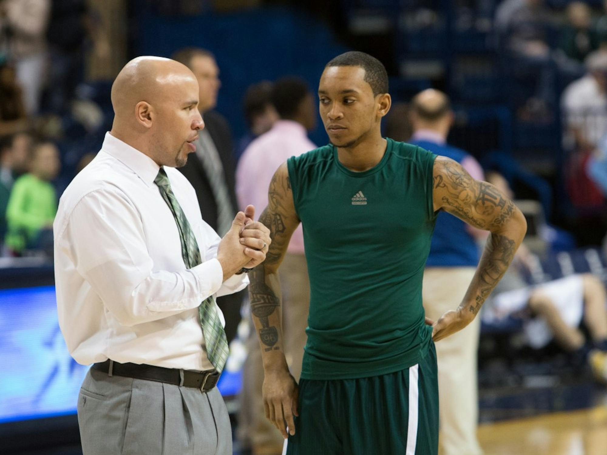 Eastern Michigan assistant coach Mike Brown chats with guard Mike Talley before the Eagles took on Toledo Saturday afternoon.