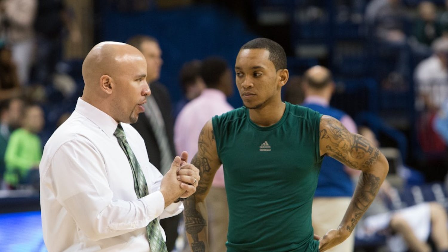 Eastern Michigan assistant coach Mike Brown chats with guard Mike Talley before the Eagles took on Toledo Saturday afternoon.