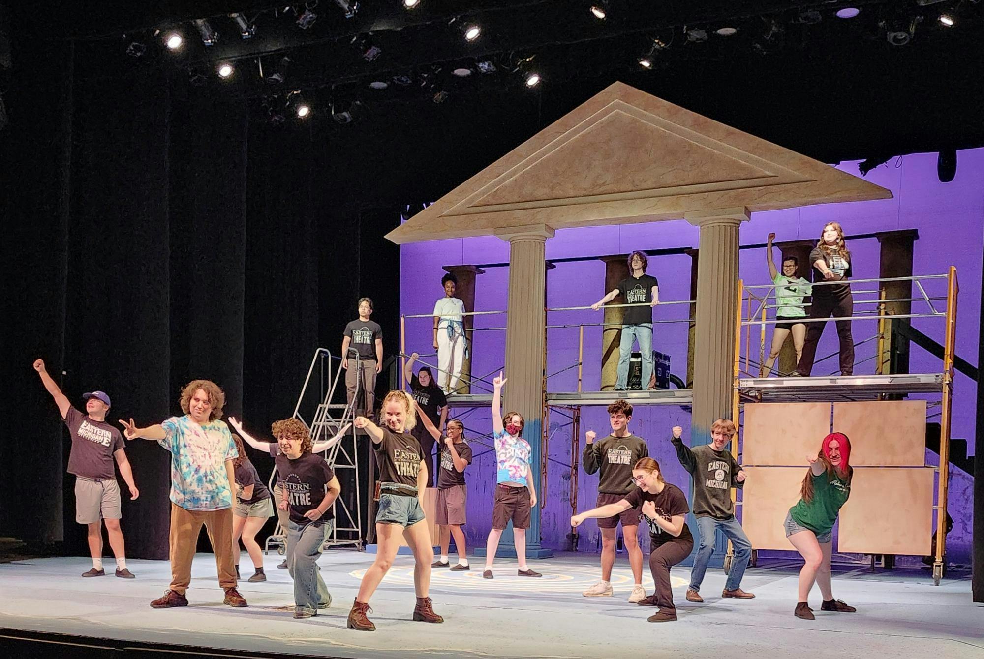 About eighteen Eastern Michigan University students dance and pose onstage during a rehearsal of EMU Theatre's production of "The Lightning Thief: A Percy Jackson Musical"