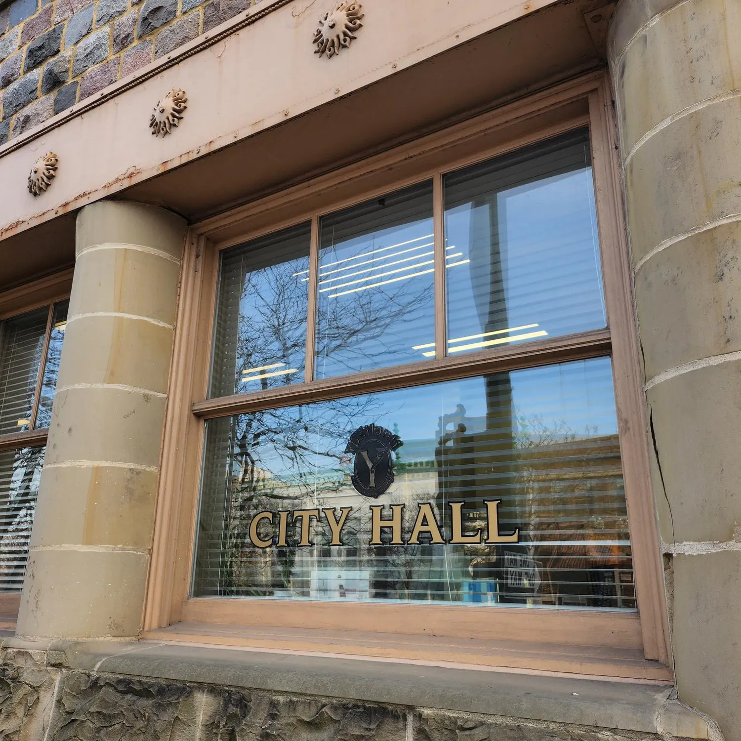 Image of a building with concrete columns and a window labeled "City Hall."