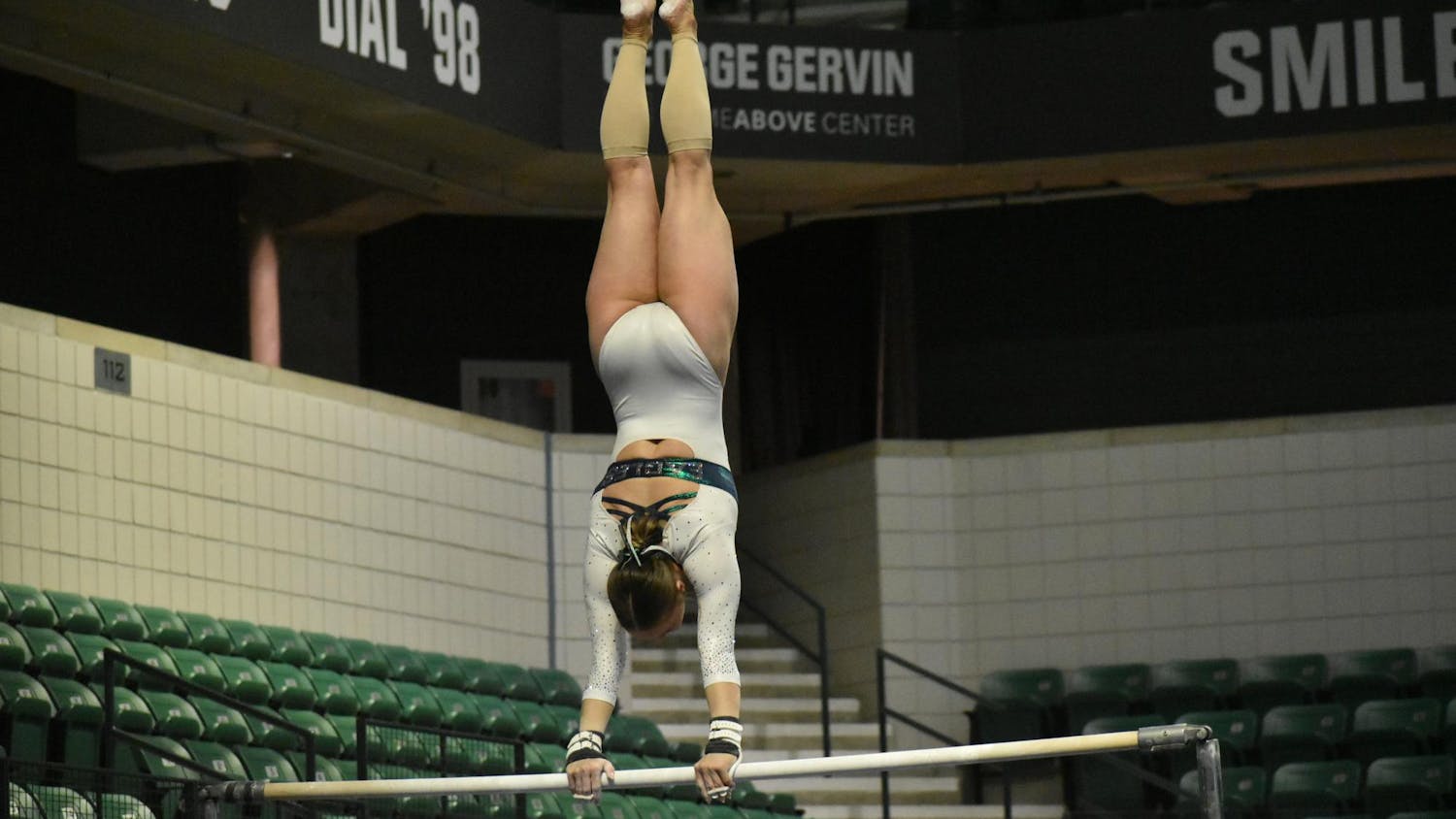 Gymnast Kyrie Lowe does a handstand on the uneven bars.