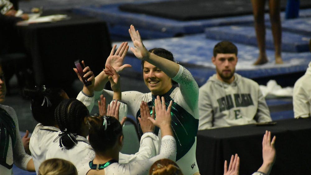 Gymnast Macy Nihart high fives her teammates.