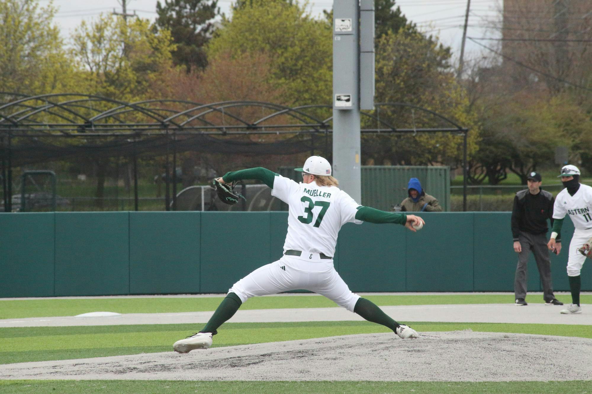 Pitcher winds up at outside baseball game.