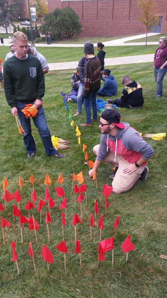 Students lined individual flags to make one big flag on the lawn outside Pray-Harrold.