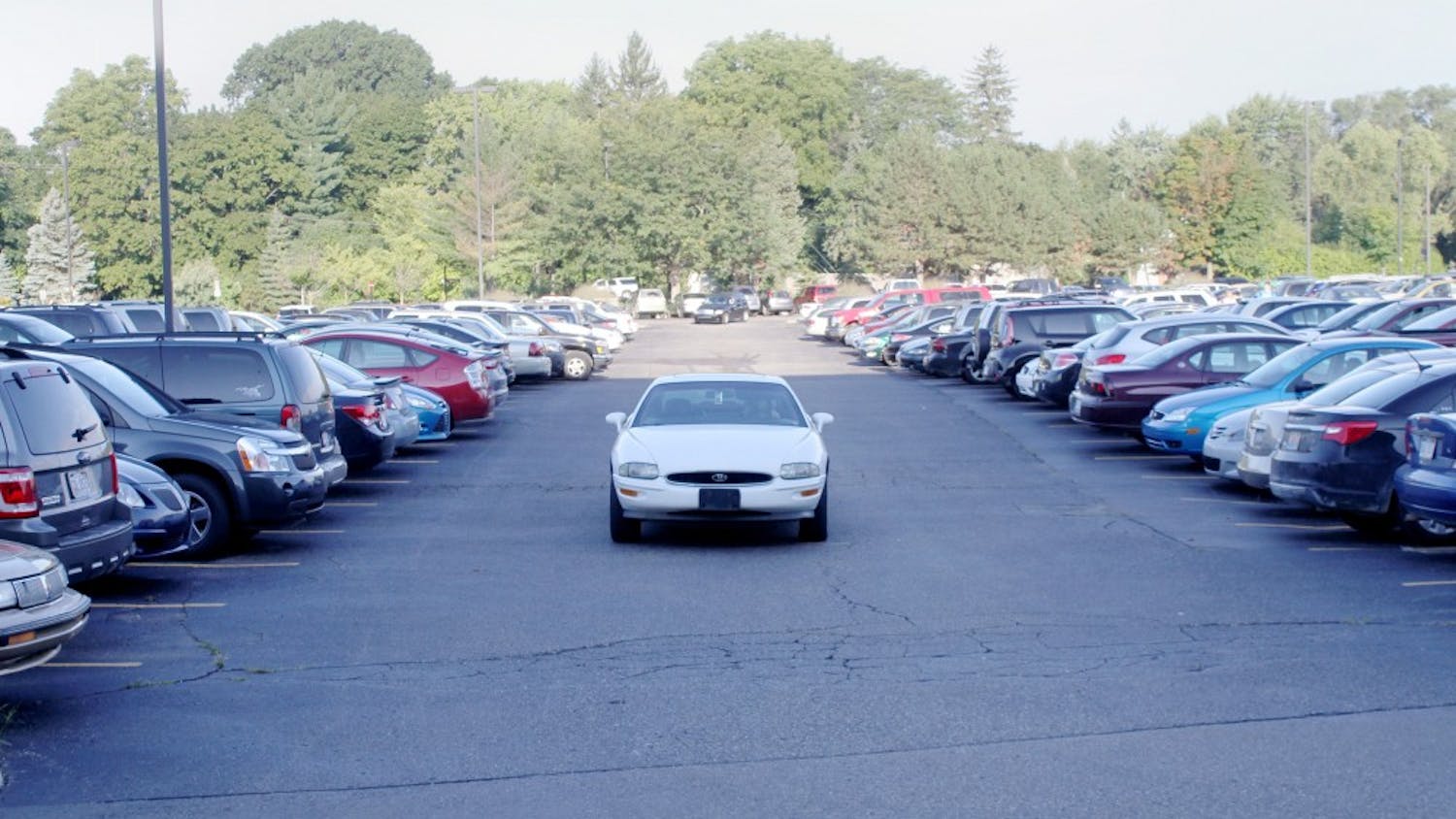 A driver stalls in a lot on campus waiting for spots to open up.
