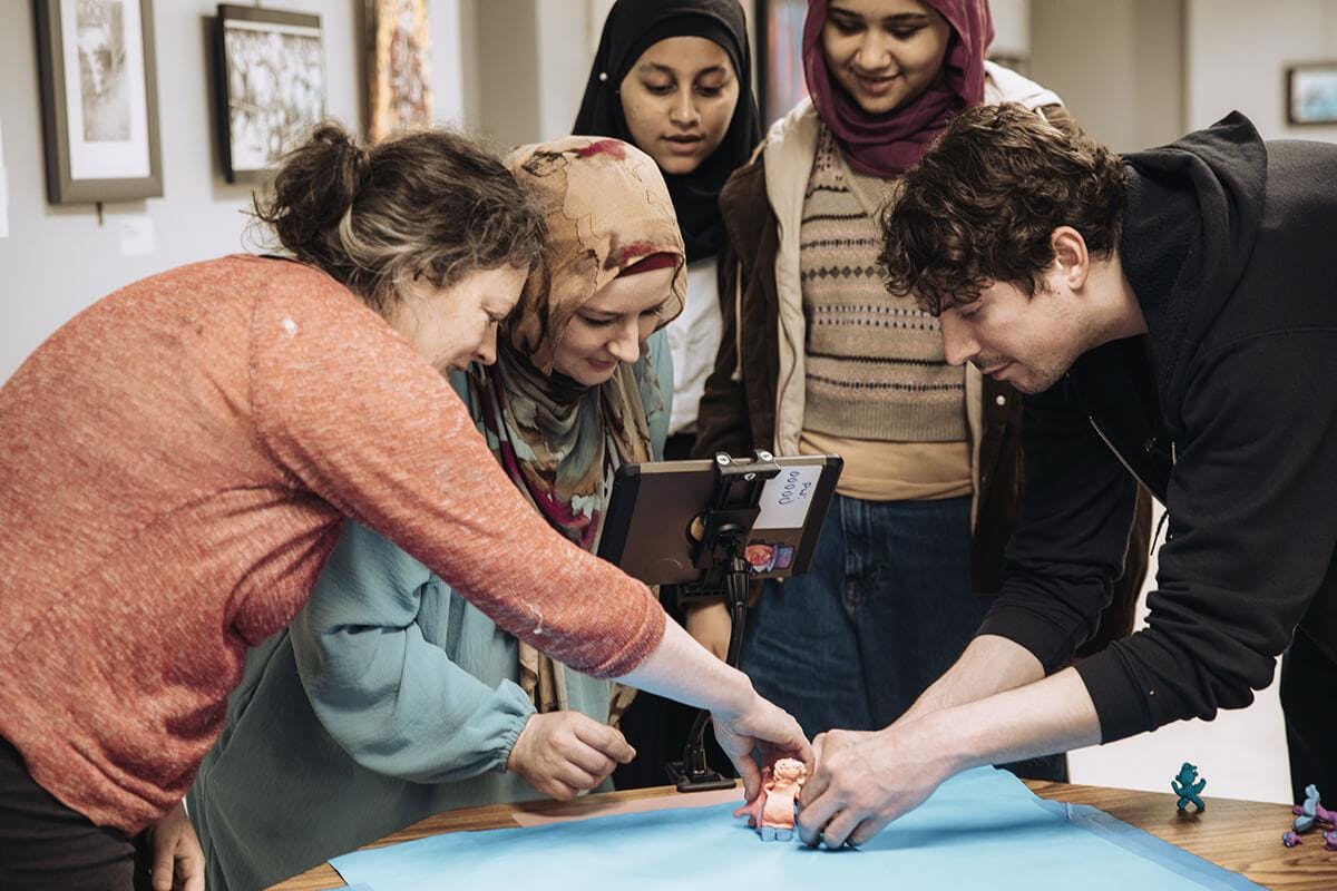 Five people gathered around a table working on creating a film.