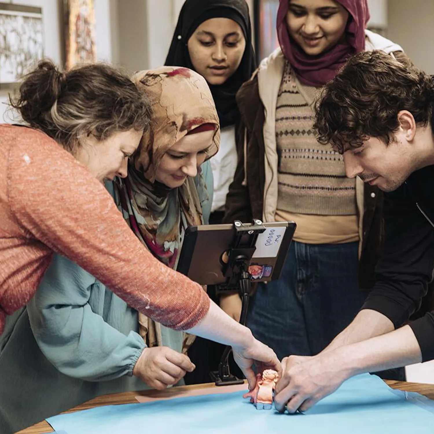 Five people gathered around a table working on creating a film.