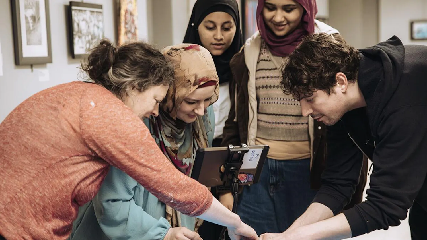 Five people gathered around a table working on creating a film.