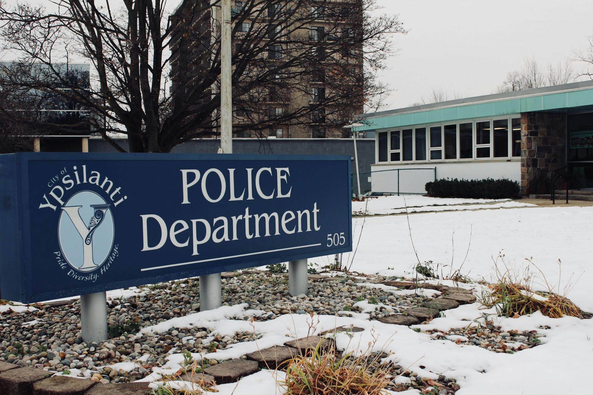 A blue sign in front of a building says, "City of Ypsilanti Police Department."