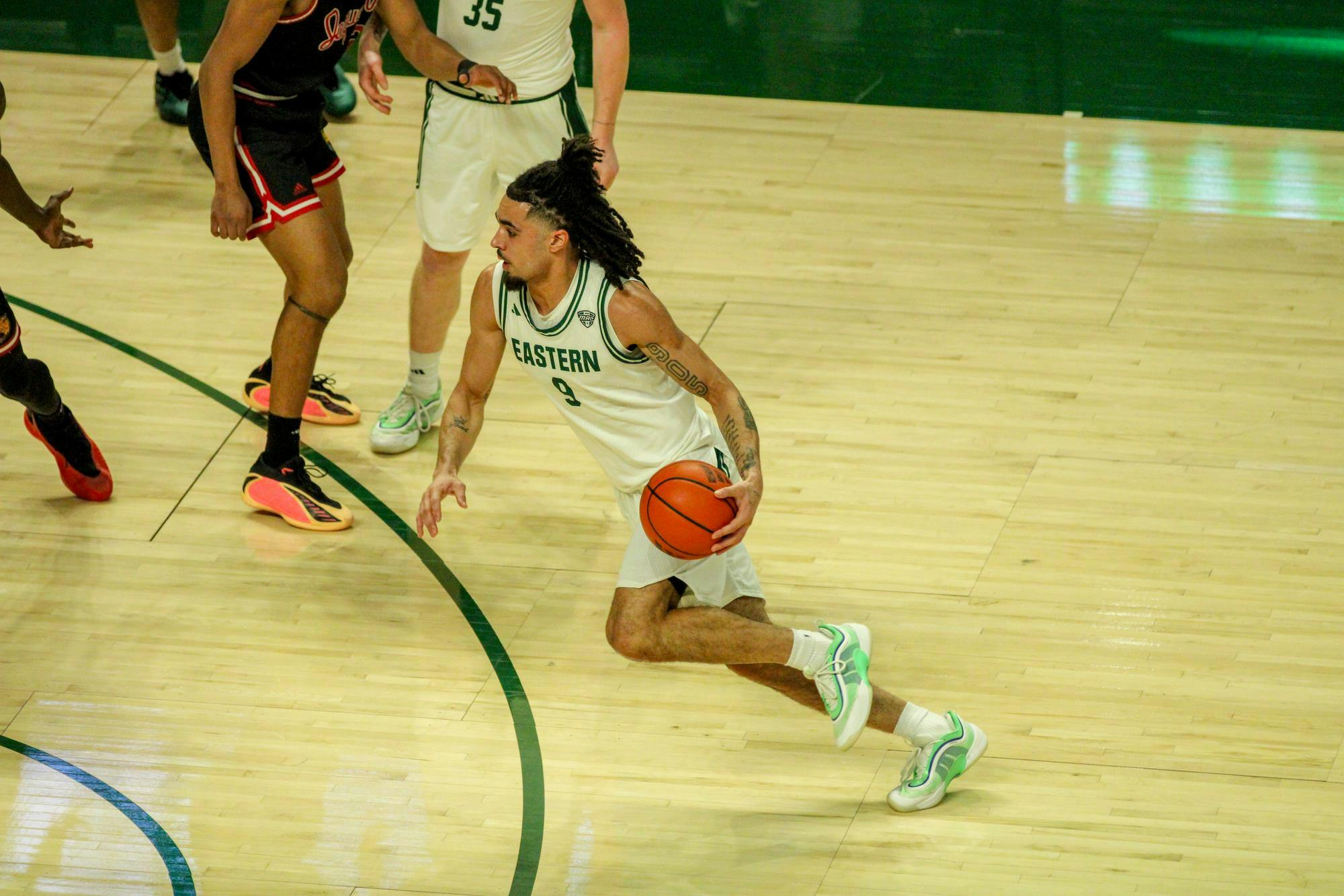 #9, in a white jersey, dribbling the basketball