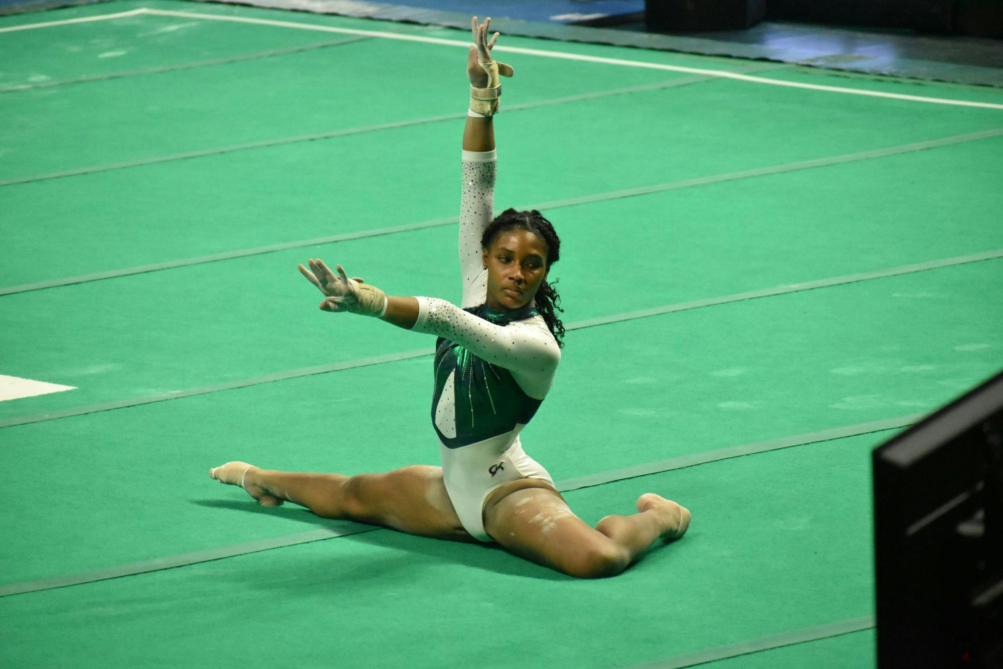 Gymnast Sanai Evans poses on the floor before preforming her routine. 