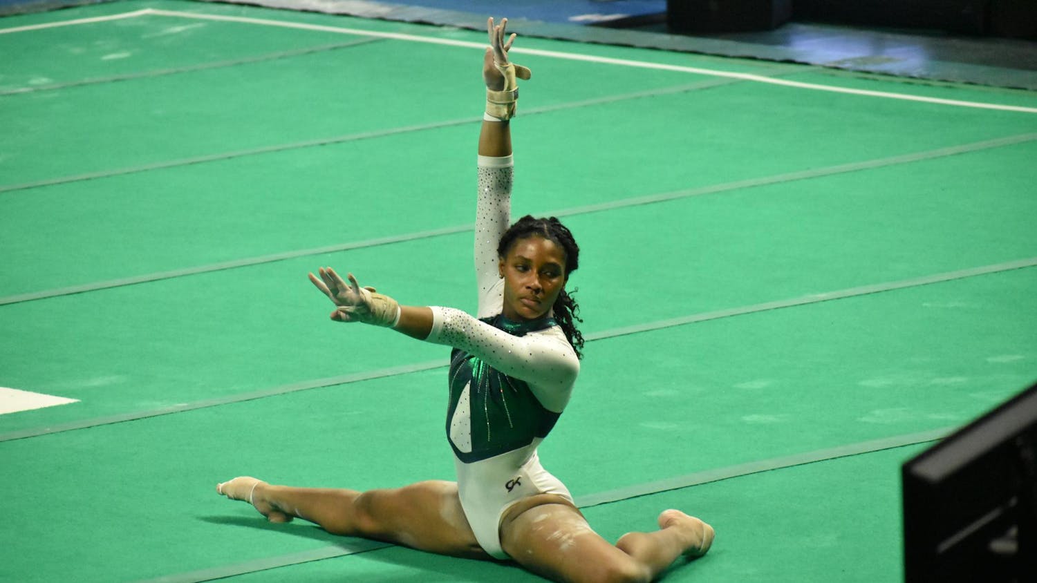 Gymnast Sanai Evans poses on the floor before preforming her routine.