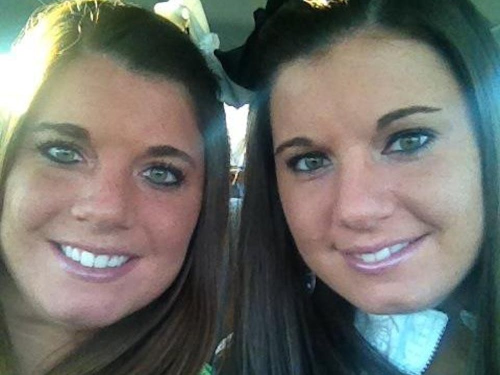 	Julia Niswender (seen here on the left, with her twin sister Jennifer on the right) was found dead Tuesday night in her Peninsular Place apartment in Ypsilanti.