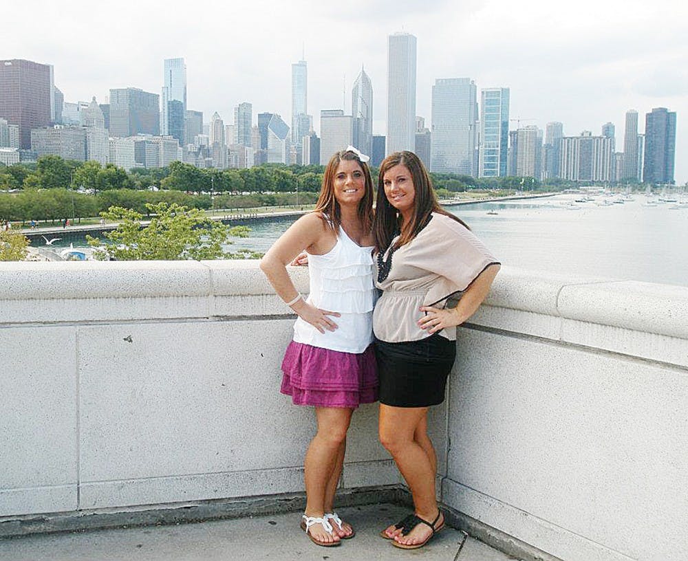 	Julia Niswender (left) and her twin sister Jennifer (right) pose in front of the Chicago skyline. Julia was found dead Tuesday night in her apartment in the Peninsular Place apartment complex in Ypsilanti.