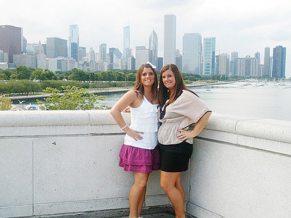 	Julia Niswender (left) and her twin sister Jennifer (right) pose in front of the Chicago skyline. Julia was found dead Tuesday night in her apartment in the Peninsular Place apartment complex in Ypsilanti.