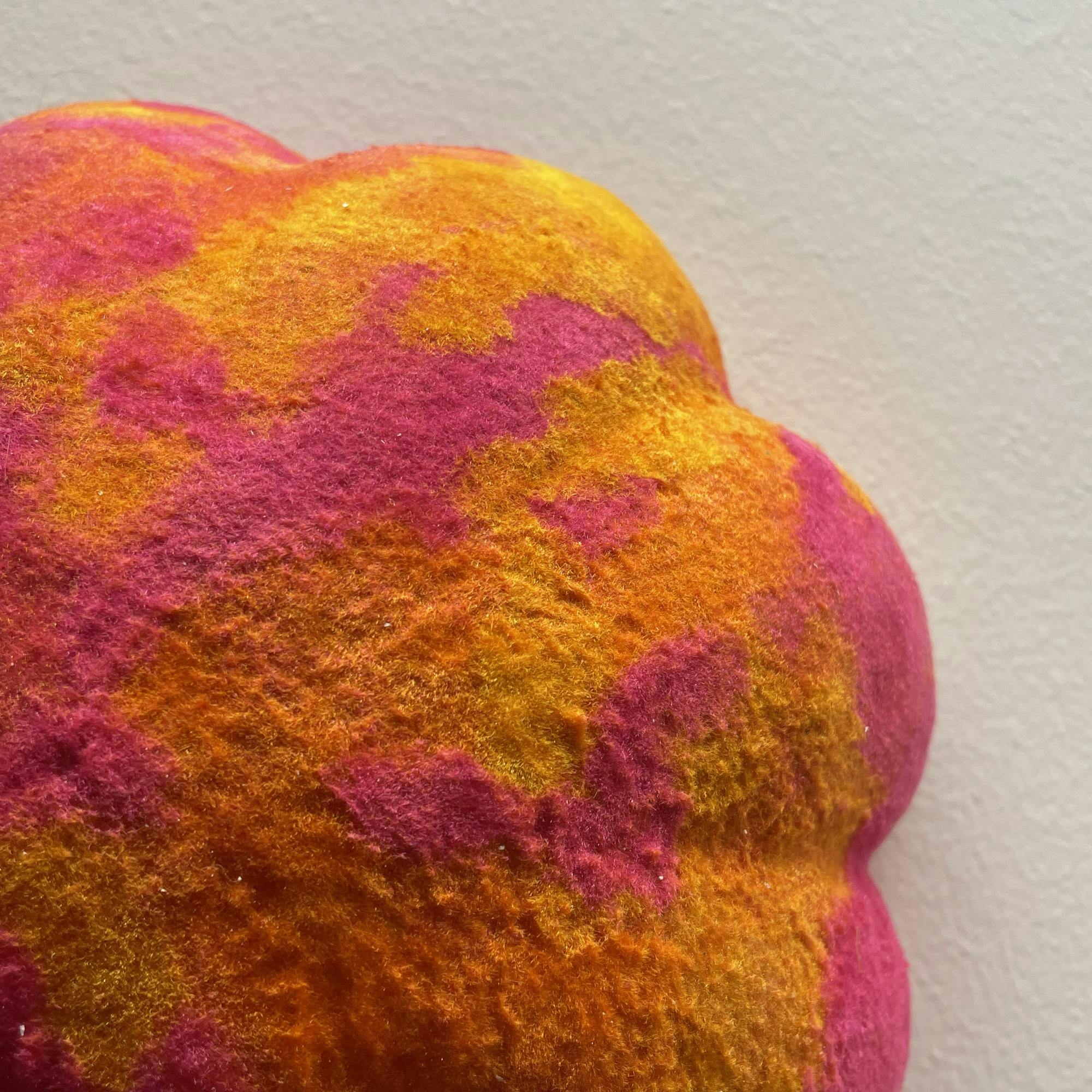 Close-up of flower-shaped design with neon pink, orange, and yellow colors. The design appears soft and fuzzy.