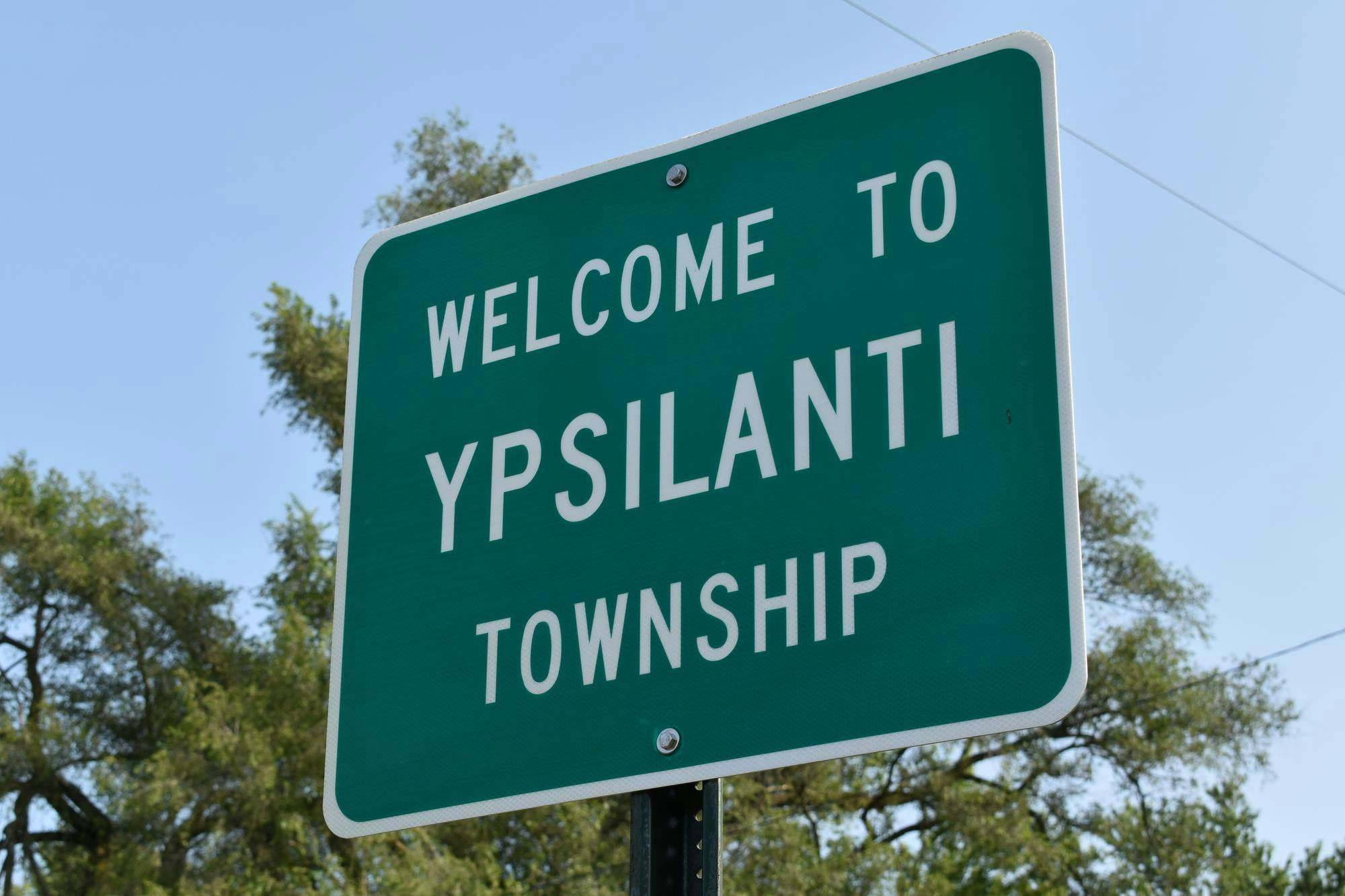 A green street sign that says "Welcome to Ypsilanti Township"