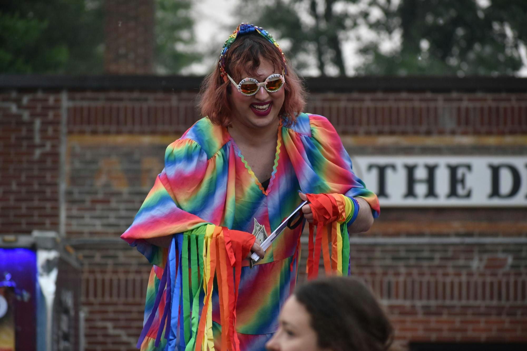 Dressed in rainbow attire, Zooey Gaychanel smiles in an outdoor area.