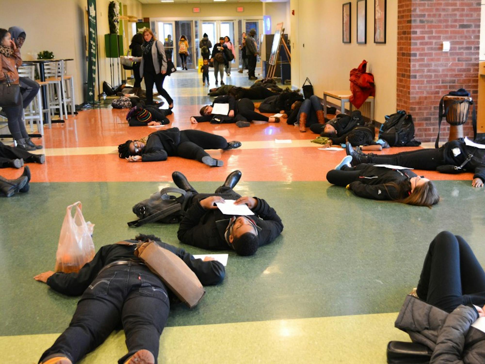 EMU students protest the Ferguson case through a die in while holding papers of those who have been killed by the police force on Dec 1rst, 2014 at the Student Center on Eastern Michigan University's campus.
