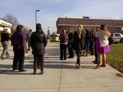 	Students and staff stand outside Snow Health Center after being evacuated in response to a burning smell Friday afternoon.