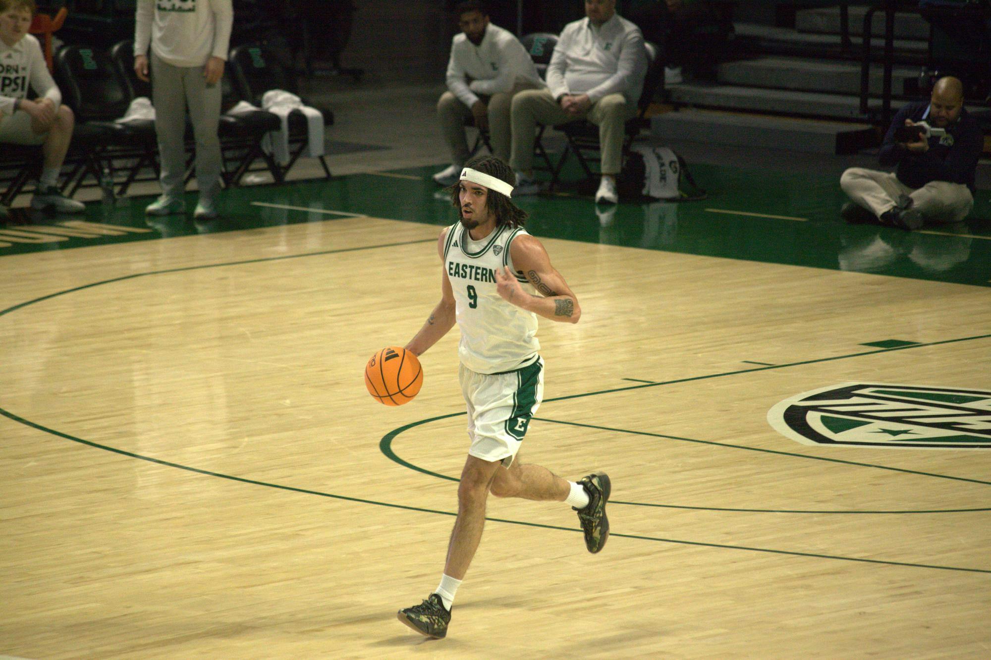 An Eastern Michigan University Men's Basketball player runs on court.