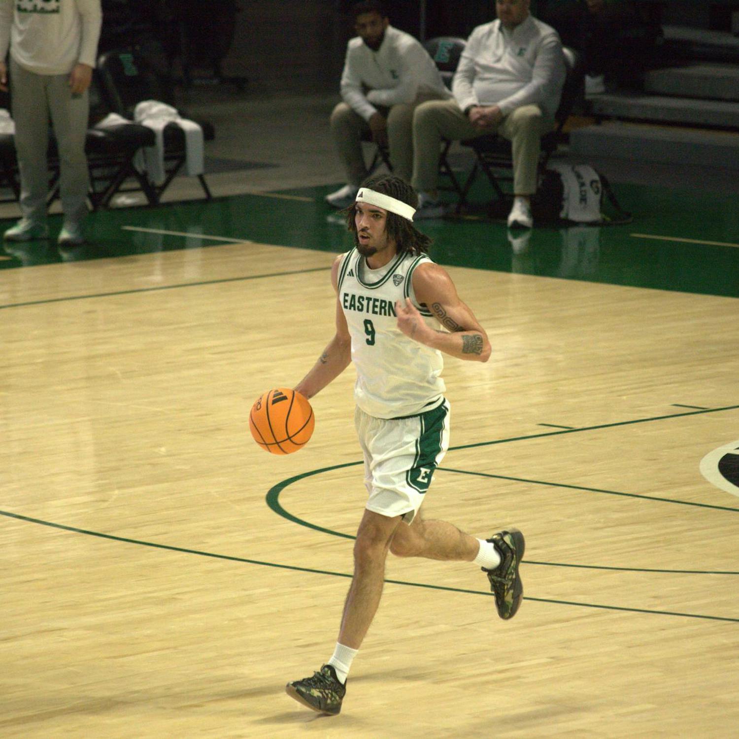 An Eastern Michigan University Men's Basketball player runs on court.
