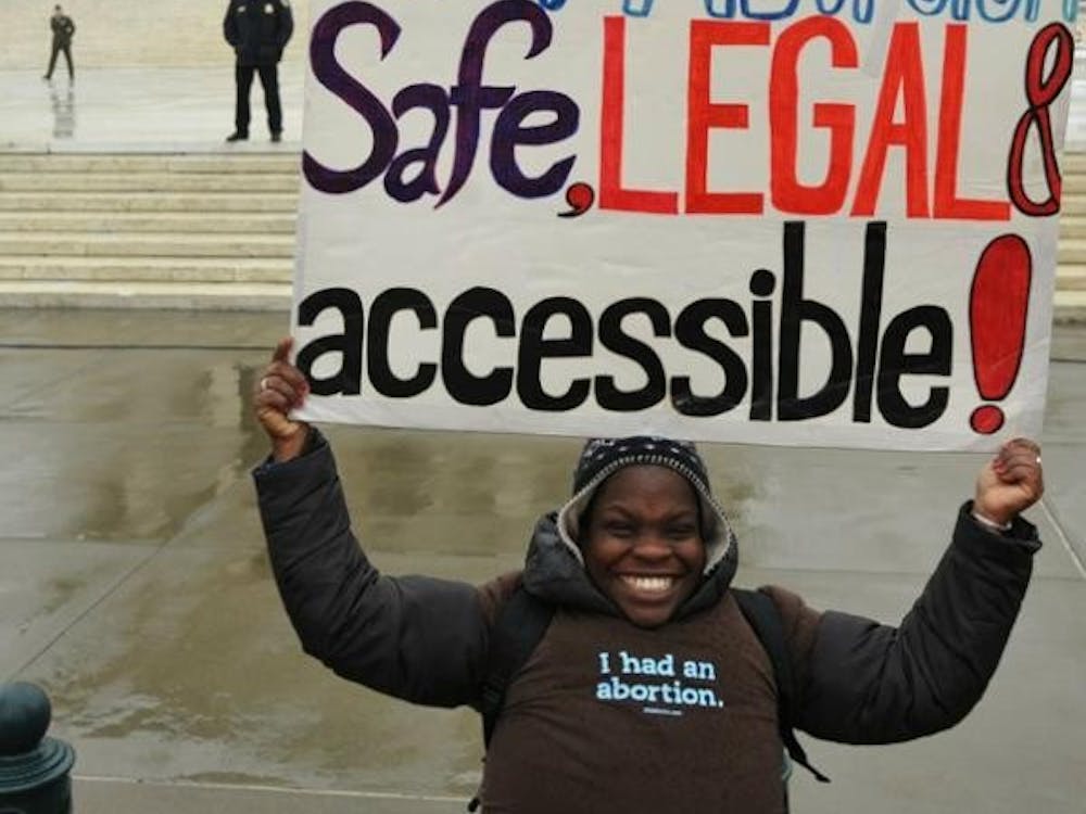 Woman poses in front of the SCOTUS building in Washington D.C. in 2012.Photo by Debra Sweet on Flickr.