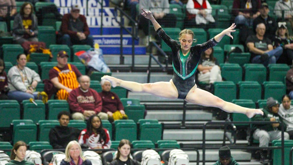 EMU gymnast, Macy Nihart, doing the splits in the air during her beam routine.