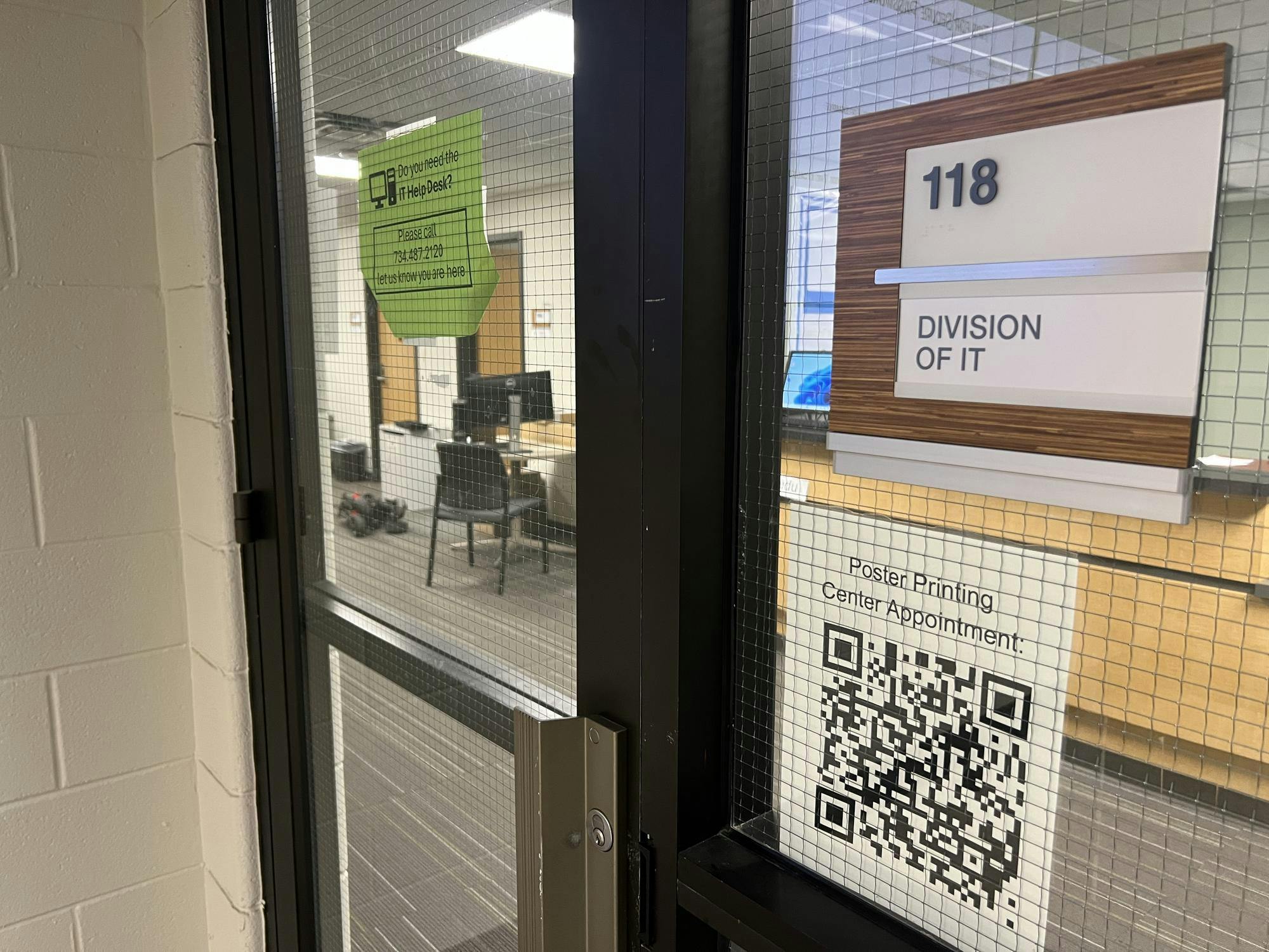 A glass door leads to room 118 of Pray-Harrold, where the Eastern Michigan University division of IT is housed.