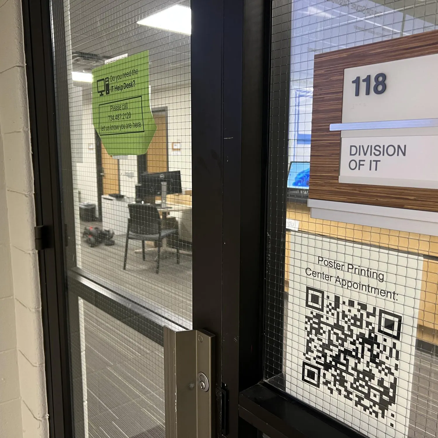 A glass door leads to room 118 of Pray-Harrold, where the Eastern Michigan University division of IT is housed.